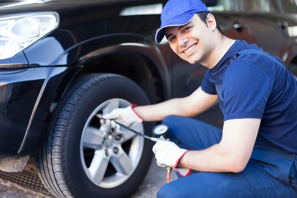 Mechanic inflating tire — Stock Photo, Image