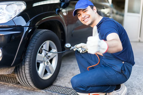 Mechanic inflating tire — Stock Photo, Image