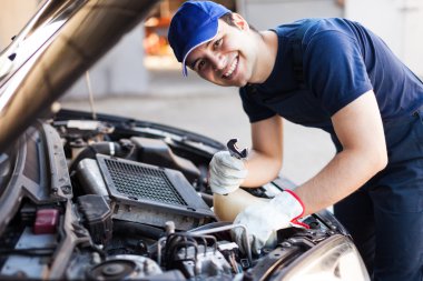 Mechanic working on car engine clipart