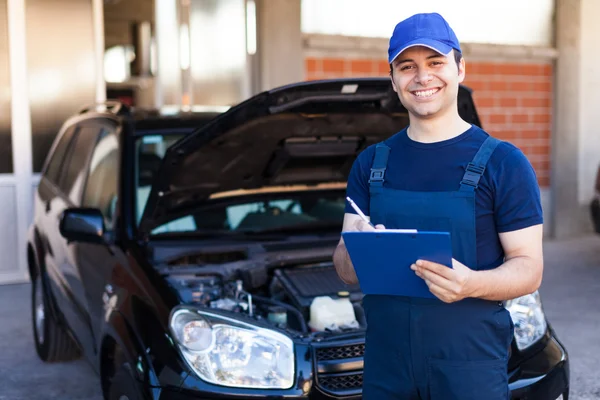 Mechanic writing on clipboard — Stock Photo, Image