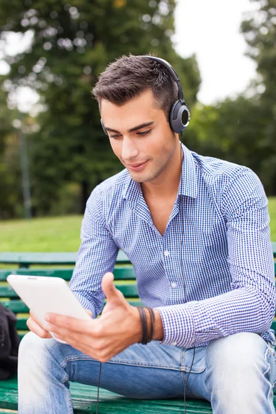 Man listening music in city park — Stock Photo, Image