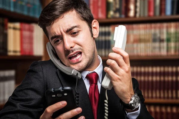 Businessman talking on many phones — Stock Photo, Image