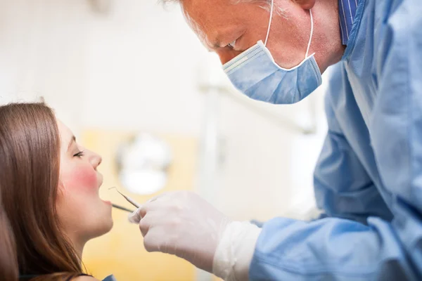 Dentista fazendo tratamento odontológico no paciente — Fotografia de Stock