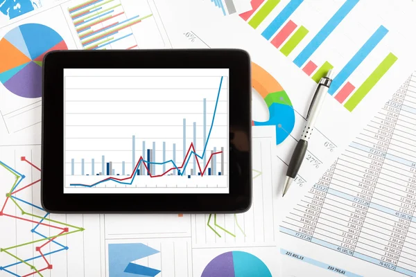 Tablet computer and financial charts — Stock Photo, Image