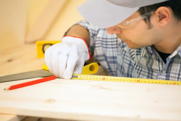 Carpenter using measuring tape — Stock Photo, Image