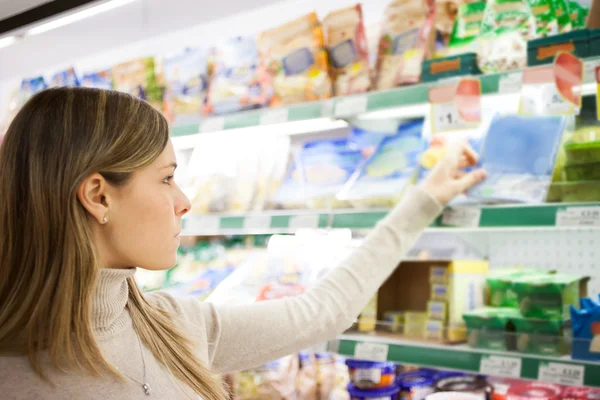 Vrouw kiezen van voeding in supermarkt — Stockfoto