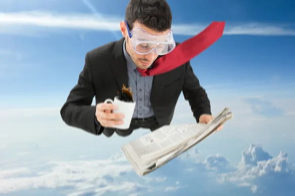 Businessman skydiving while reading newspaper — Stock Photo, Image