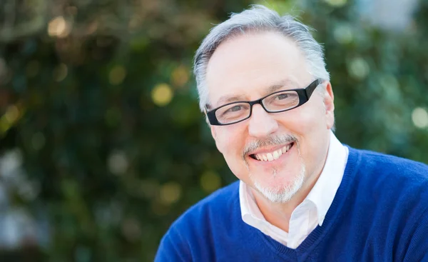 Senior man smiling in park — Stock Photo, Image