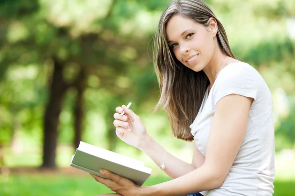 Jonge vrouw studeren aan park — Stockfoto