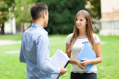 Genç çift dışarıda konuşuyor.