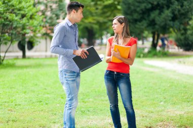Genç çift dışarıda konuşuyor.