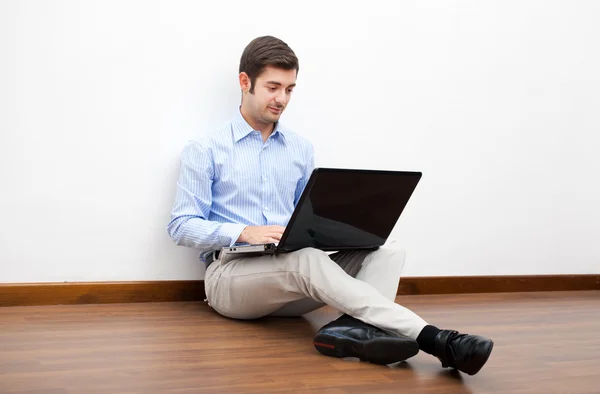 Uomo seduto al piano con computer portatile — Foto Stock