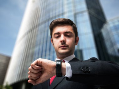 İş adamı saatine bakıyor.