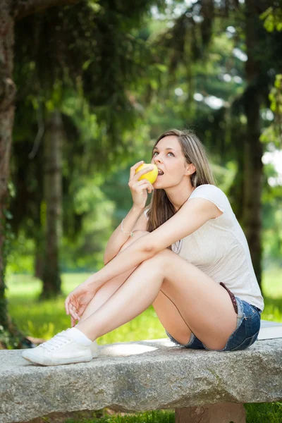 Vrouw die een appel eet — Stockfoto