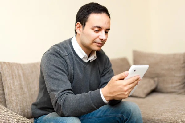 Homme sur canapé avec tablette numérique — Photo