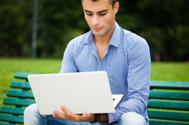 Açık havada dizüstü bilgisayar kullanan adam