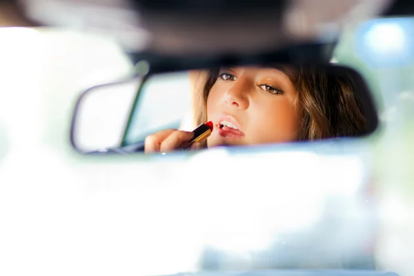 Mulher aplicando maquiagem durante a condução — Fotografia de Stock