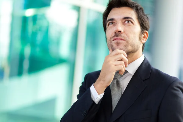 Businessman with hand on chin — Stock Photo, Image