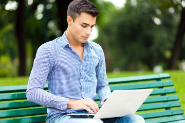 Açık havada dizüstü bilgisayar kullanan adam