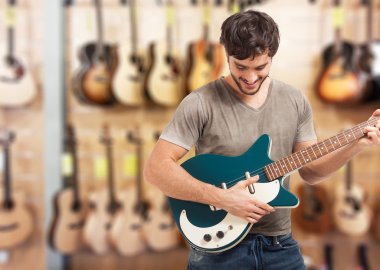 Man playng a guitar in a store clipart