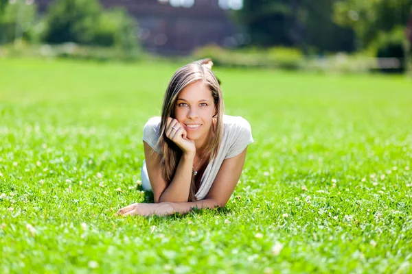 Kvinnlig student liggande i gräset — Stockfoto