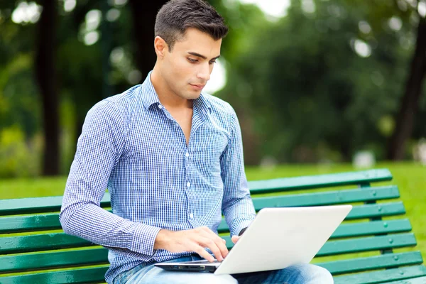 Homem usando computador portátil ao ar livre — Fotografia de Stock