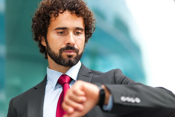 Empresário olhando para o seu relógio — Fotografia de Stock