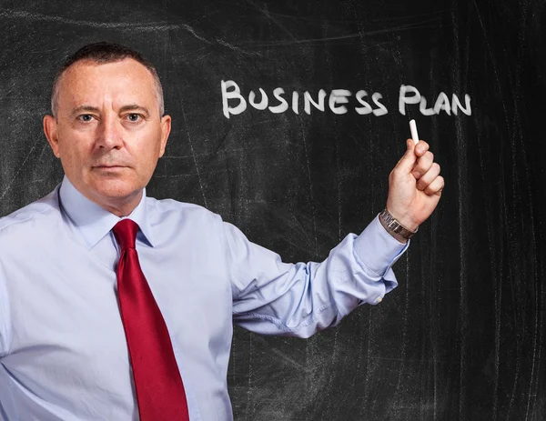 Businessman writing Business Plan on blackboard — Stock Photo, Image