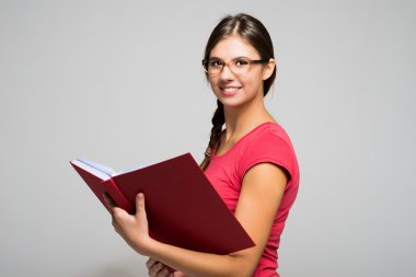 Elinde kitap tutan genç bir kadın