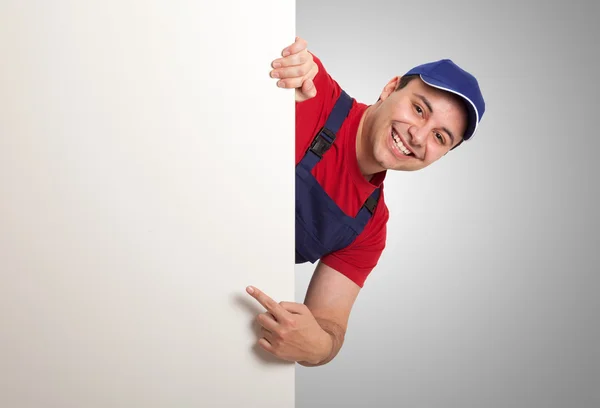 Worker pointing his finger to a blank board — Stock Photo, Image