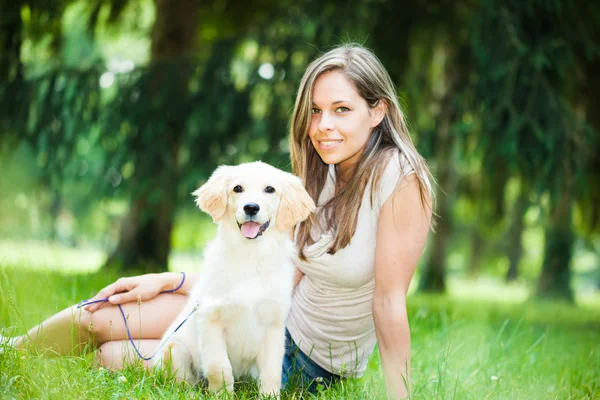 Kvinna som spelar med henne hennes golden retriever utomhus — Stockfoto