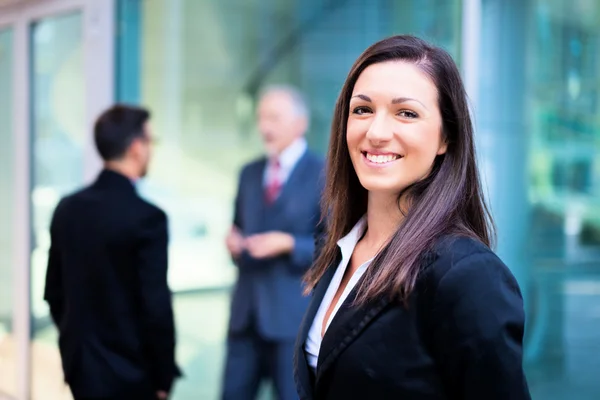 Mulher de negócios na frente de um grupo de empresários — Fotografia de Stock