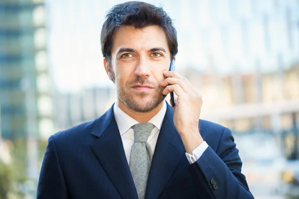 Homem de negócios bonito falando no telefone celular — Fotografia de Stock