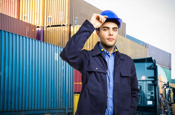 Werknemer tegenover een stapel van containers — Stockfoto