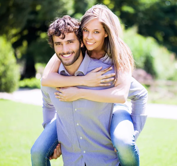 Man geven piggy terug rit naar vriendin — Stockfoto