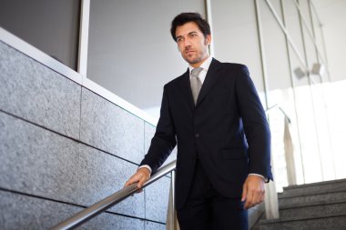 İşadamı merdivenlerden iniyor.