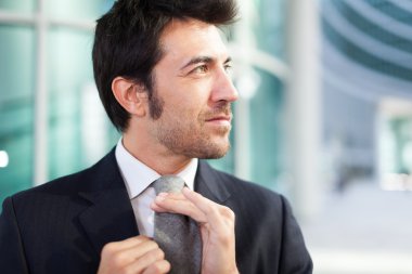 Businessman adjusting his necktie clipart