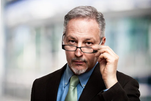 Businessman holding his eyeglasses — Stock Photo, Image
