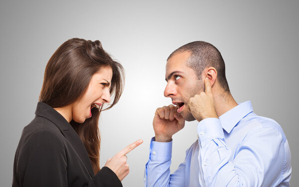 Man covering ears in front of woman