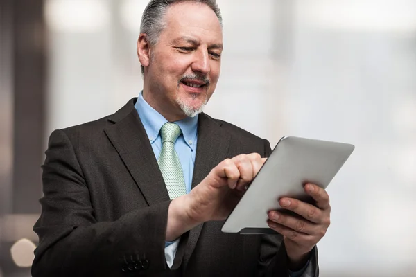 Tablet bilgisayar kullanan gülümseyen adam — Stok fotoğraf