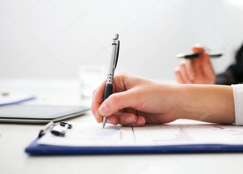 Business person writing on sheet of paper — Stock Photo © minervastock