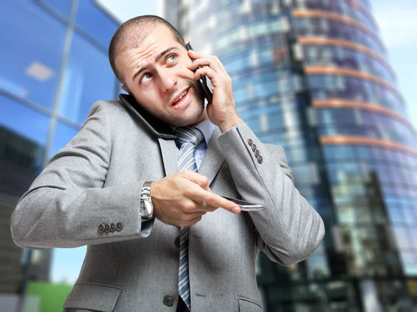 Businessman talking on many phones — Stock Photo, Image