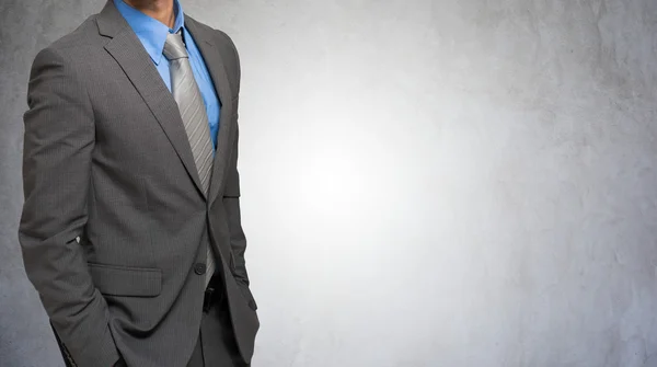 Businessman against concrete background — Stock Photo, Image