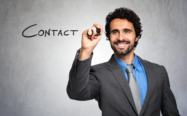 Businessman writing 'contact us' — Stok fotoğraf