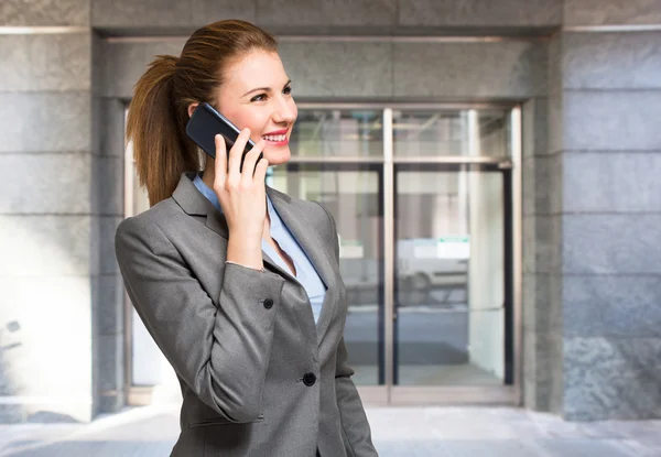 Empresária usando um celular — Fotografia de Stock