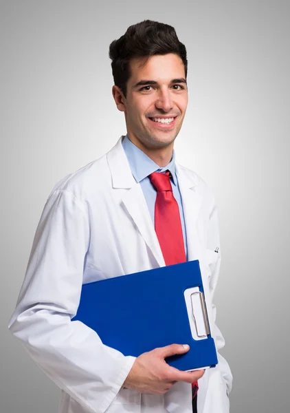 Médico sorridente segurando uma área de transferência — Fotografia de Stock