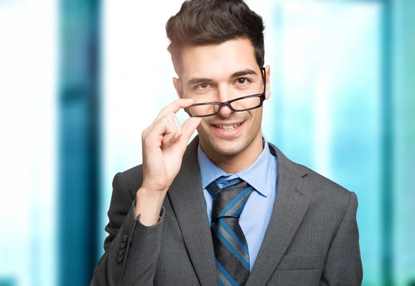 Empresario sosteniendo sus anteojos — Foto de Stock