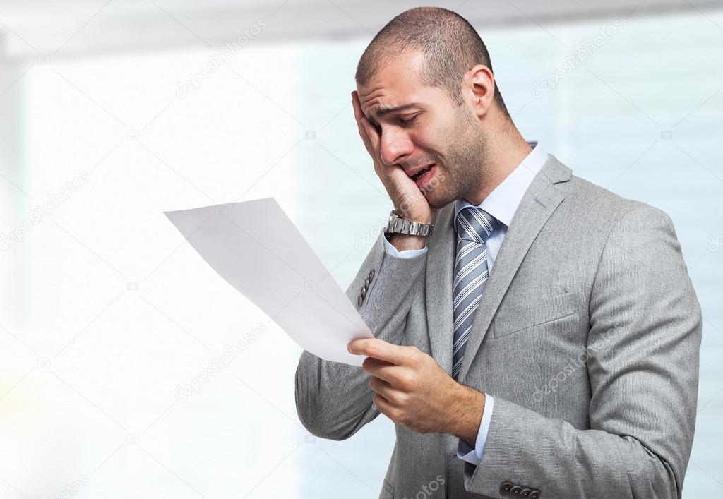 Stressed businessman reading a document