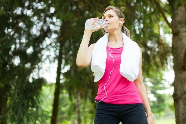 Sportliche Frau trinkt Wasser — Stockfoto