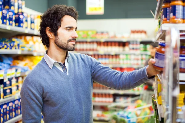 Mann kauft im Supermarkt ein — Stockfoto